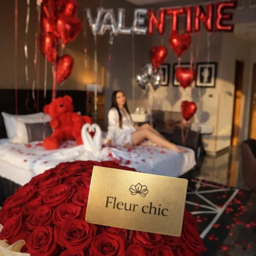 bouquet de roses rouges avec emballage élégant devant une chambre décorée pour la Saint-Valentin