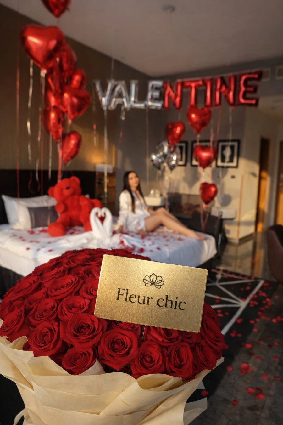 bouquet de roses rouges avec emballage élégant devant une chambre décorée pour la Saint-Valentin