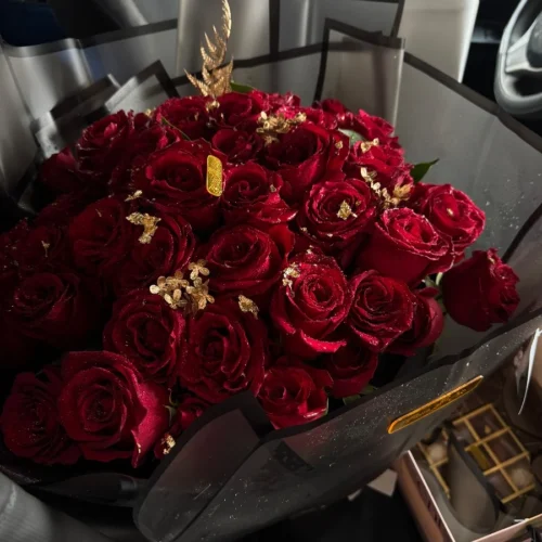 bouquet de roses rouges premium avec décor doré dans un emballage noir élégant