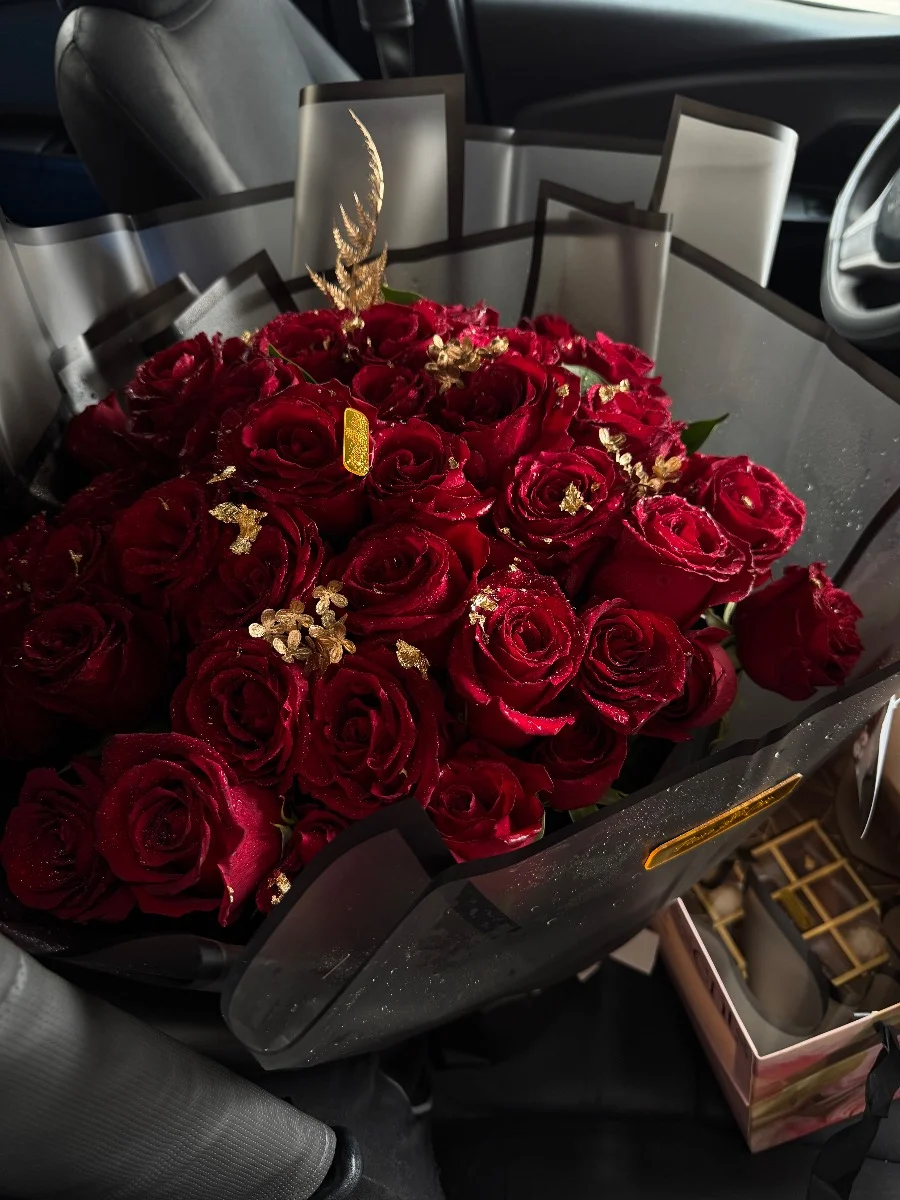 bouquet de roses rouges premium avec décor doré dans un emballage noir élégant