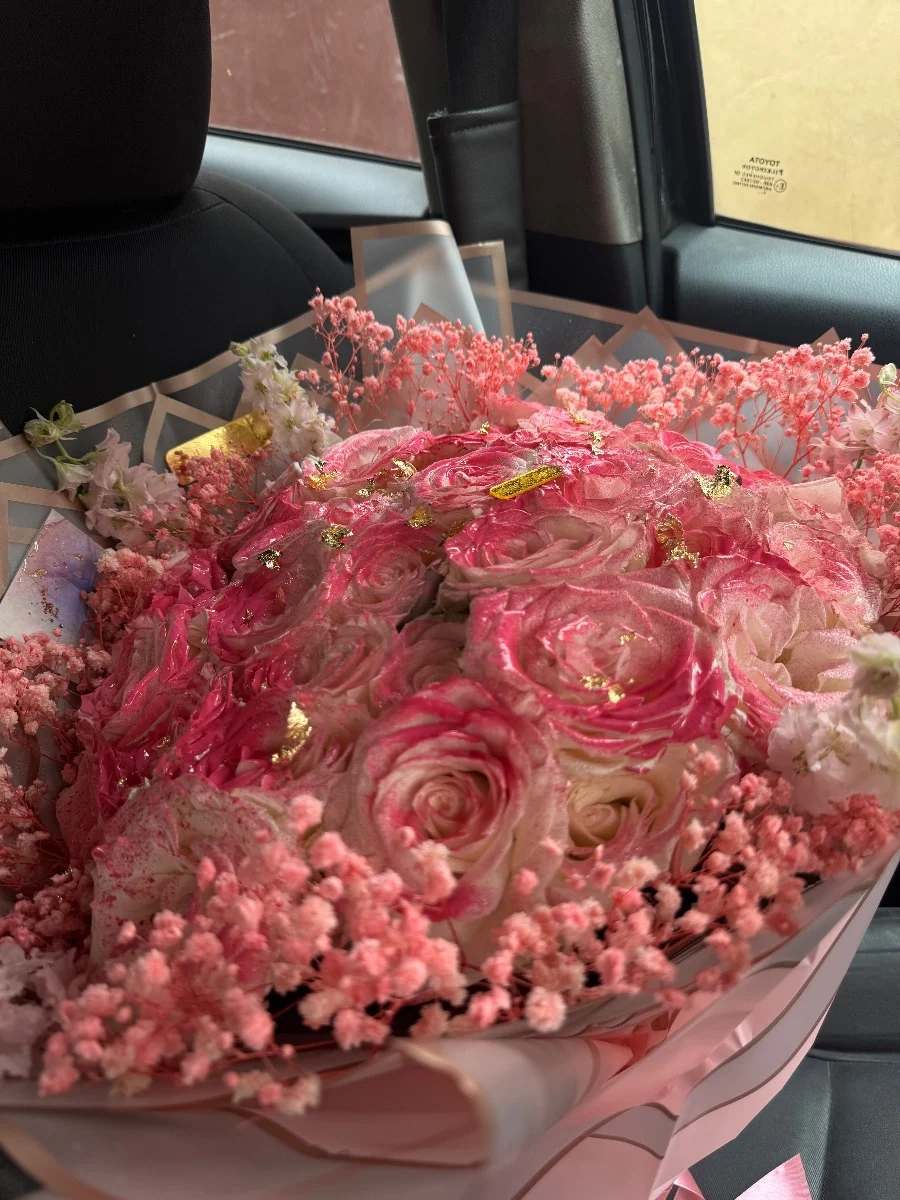 Bouquet de roses roses et blanches avec décor doré et fleurs séchées dans un emballage élégant