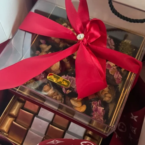 Coffret de chocolats décoré de fleurs avec un ruban rouge