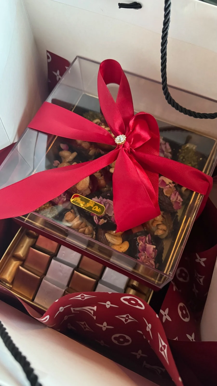 Coffret de chocolats décoré de fleurs avec un ruban rouge